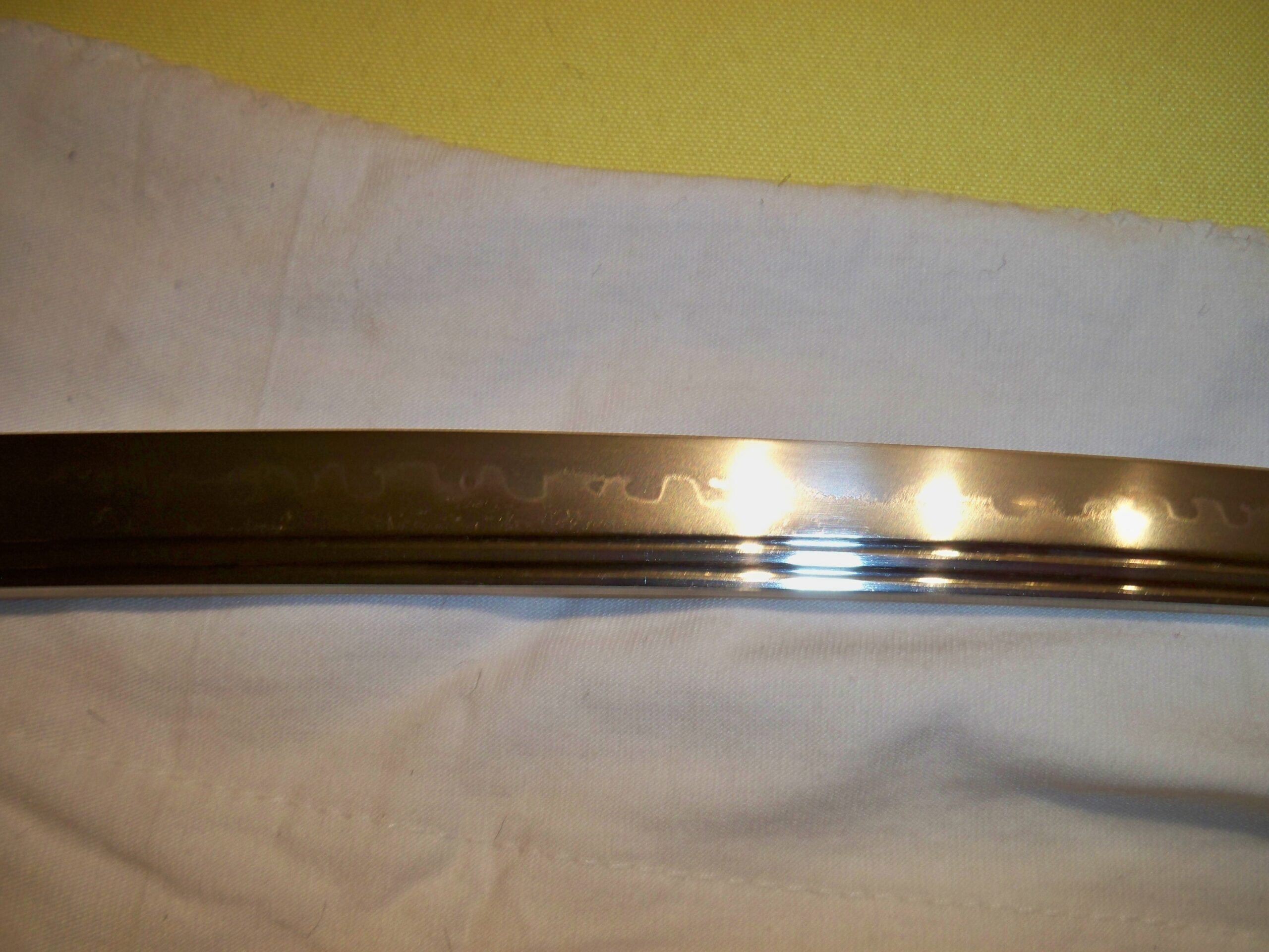 Close-up of a katana blade showing the hi groove and hamon temper line